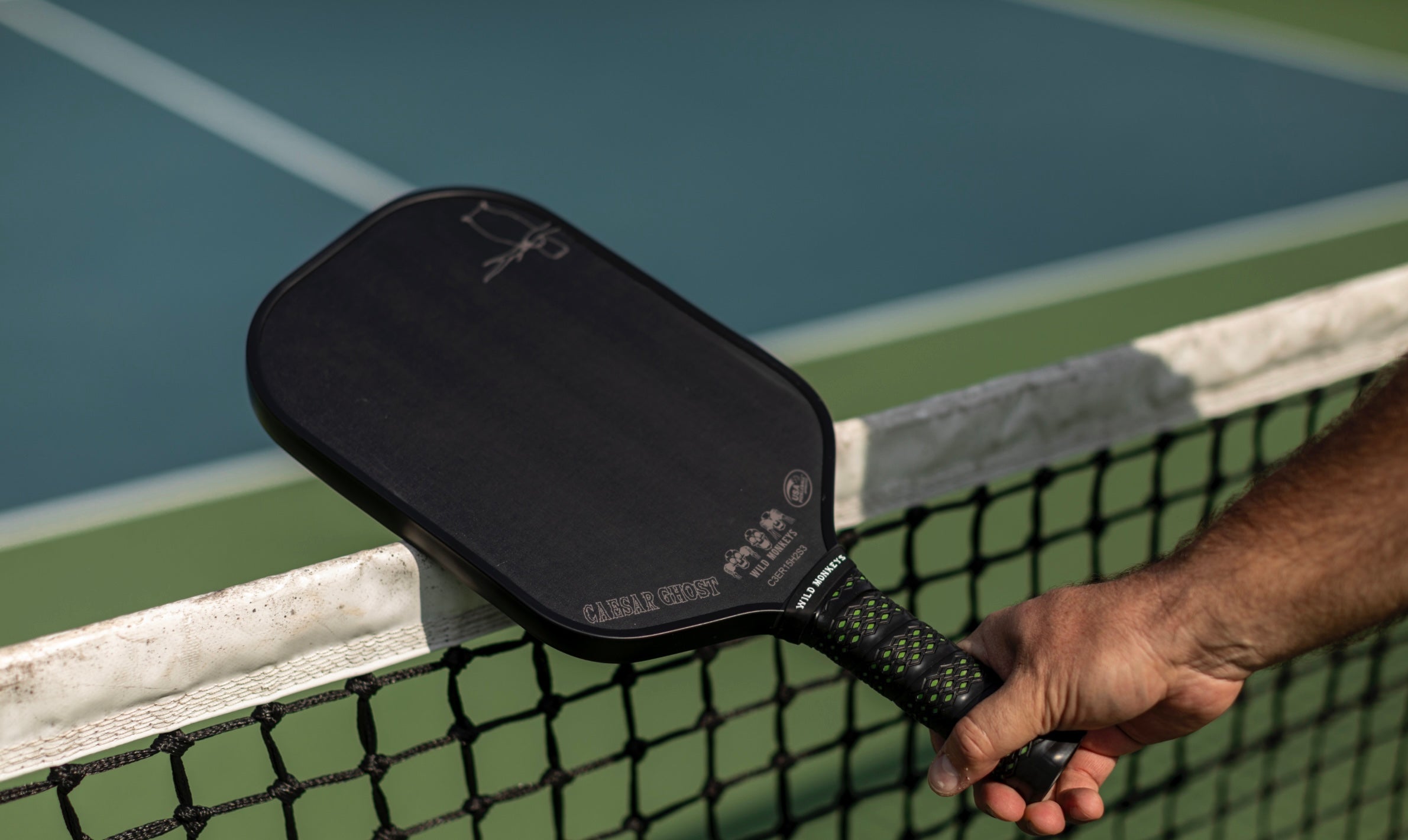 Man holds pickleball paddle uk over a net